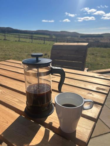 a coffee maker and a cup of coffee on a table at Barnharrow Holiday Pods in Newton Stewart