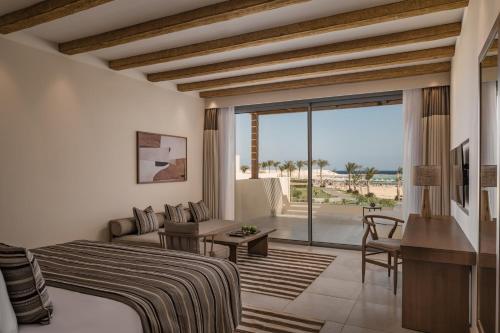 a bedroom with a bed and a view of the beach at JAZ Elite Riviera in Marsa Alam City