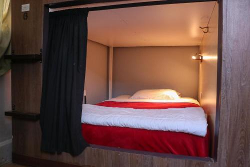a small bed in a room with a mirror at Blue House Youth Hostel in Quito