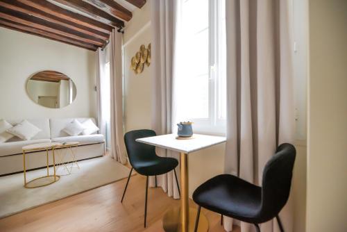 une pièce avec une table et deux chaises et un lit dans l'établissement CIA - Studio near Louvre & Tuileries, à Paris