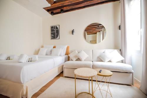 un salon blanc avec un canapé et une table dans l'établissement CIA - Studio near Louvre & Tuileries, à Paris