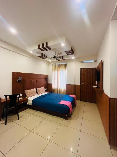 a bedroom with a bed and a desk and a television at White Portico in Thekkady