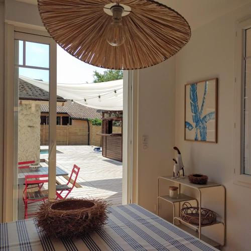 d'une salle à manger avec une table et un ventilateur de plafond. dans l'établissement Maison Peonia, à La Teste-de-Buch