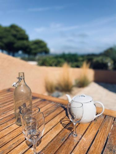 - une table avec des verres à vin et une bouteille dans l'établissement Maison 5 pers - vue étang - nature - piscine, à Fitou