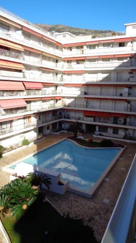 un grand immeuble d'appartements avec une grande piscine dans l'établissement Studio Le Marly, à Menton