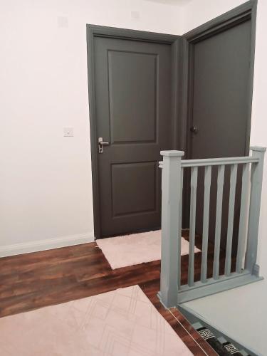 a hallway with a black door and a staircase at Marina & Seagulls in East Cowes