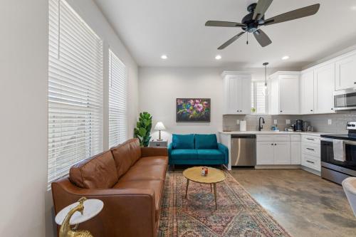 a living room with a brown couch and a blue chair at NEW Acadian House KING Bed Cajun Luxury Nespresso in Lafayette
