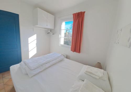 a white room with a bed and a window at GRILEG- Pour des vacances idéales en famille ! T2 cabine dans résidence avec piscine chauffée in Grimaud
