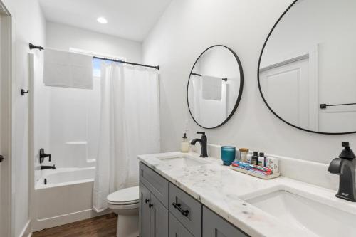 ein weißes Badezimmer mit Waschbecken und Spiegel in der Unterkunft NEW Acadian House KING Bed Cajun Luxury Nespresso in Lafayette