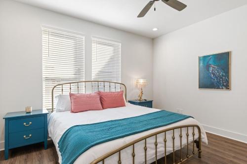ein Schlafzimmer mit einem Bett und zwei Nachttischen und einem Fenster in der Unterkunft NEW Acadian House KING Bed Cajun Luxury Nespresso in Lafayette