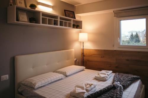 a bedroom with a bed with towels on it at App Panoramico 300 mt dalle Piste Relax e Vista Alpi in Passo del Tonale