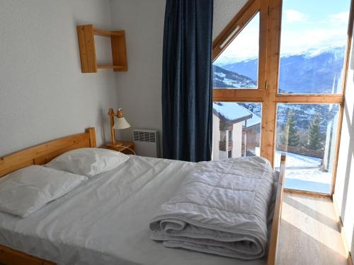 une chambre avec un lit et une grande fenêtre dans l'établissement Appartement 2 pièces pour 7 pers. à Vallandry proche des pistes - FR-1-411-649, à Landry