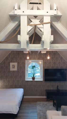 a room with a bed and a chandelier at B&B Het Schipperskerkje in Tolkamer