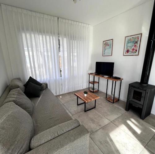 a living room with a couch and a television at Del arroyo Tandil in Tandil