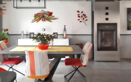 ChampcueilにあるMaison accueillante avec jardin à Champcueilのダイニングルーム(テーブル、赤い椅子付)