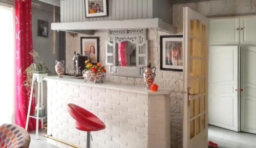 ChampcueilにあるMaison accueillante avec jardin à Champcueilのリビングルーム(レンガ造りの暖炉、赤いスツール付)