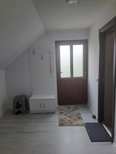 an empty room with a door and a rug at Sàndor-lak apartman in Ciceu