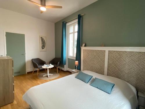 a bedroom with a large white bed with blue pillows at Les Mariniers Chambres d'Hôtes à la campagne avec aire de jeux - Spa nordique en option in Mareuil-sur-Cher