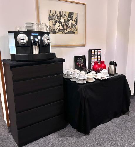 a black table with cups and plates on it at Hotel Erzgiesserei Europe in Munich
