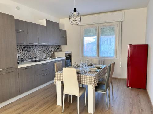 a kitchen with a table with chairs and a red refrigerator at A Casa di Bruna in Rivalta
