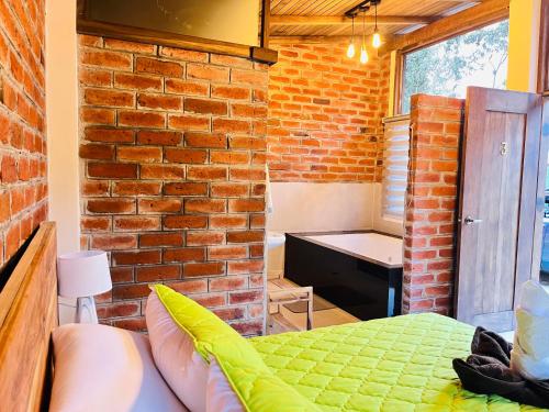 a room with a brick wall and a bed in it at Hostería RIVER PARADISE in Río Negro