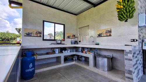 una cucina con due lavelli e una finestra e banane di Finca mi Rancho a Pereira