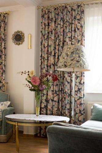a living room with a table with a vase of flowers at Hotellerie Gasthaus Schubert in Garbsen