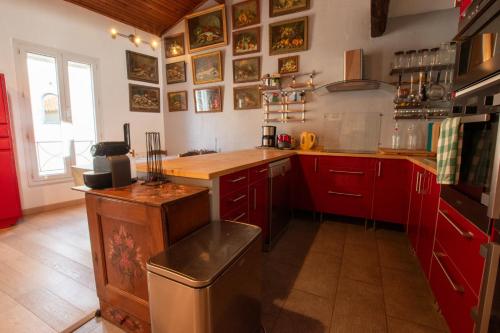 une cuisine avec des placards rouges et un comptoir en bois dans l'établissement L'Escale - Clim, Terrasse, à Arles