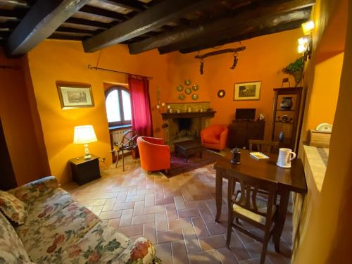 a living room with a couch and a table and a fireplace at Il borgo di Firenzuola Camere con camino in Acquasparta