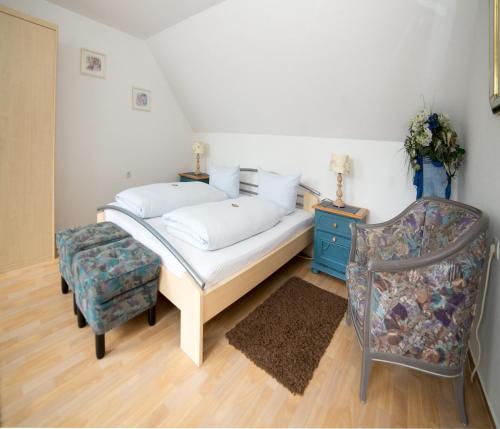 a bed and a chair in a room at Hotellerie Gasthaus Schubert in Garbsen