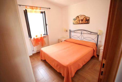 a bedroom with a bed with an orange bedspread at Charming House in Vieste with Shared Pool and Terrace in Vieste