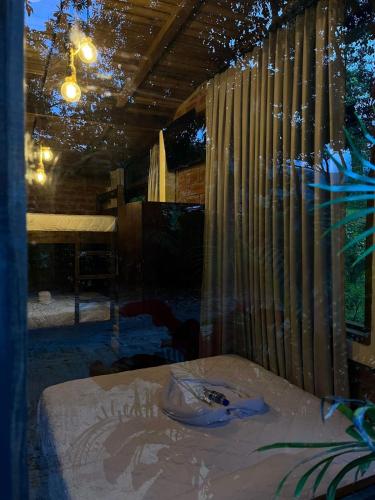 a room with a bed and a window with curtains at Hostería RIVER PARADISE in Río Negro
