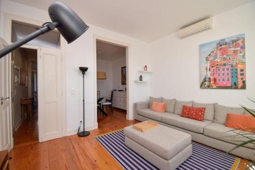 a living room with a couch and a table at Casa Tejo in Cruz Quebrada