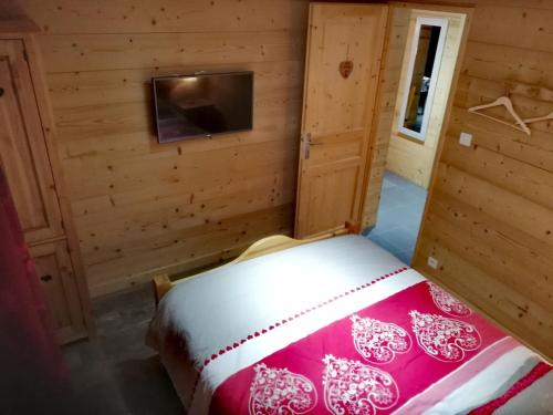 une chambre avec un lit dans une cabane en bois dans l'établissement logement cosy entre lac et montagnes, à Larringes