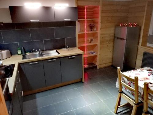 une cuisine avec un évier et un réfrigérateur dans l'établissement logement cosy entre lac et montagnes, à Larringes