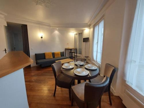un salon avec une table, des chaises et un canapé dans l'établissement Superb cozy & spacious apartment - Paris 12th, à Paris