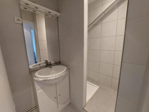 une salle de bain blanche avec un lavabo et un miroir dans l'établissement Superb cozy & spacious apartment - Paris 12th, à Paris