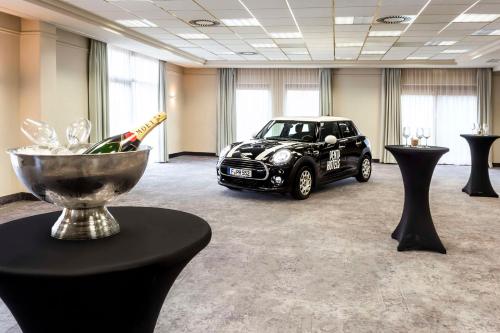 a black car parked in a room with tables at pentahotel Eisenach in Eisenach