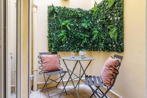 une table et deux chaises à côté d'un mur vert dans l'établissement 1 Bdr Duplex Downtown - AC, à Nice