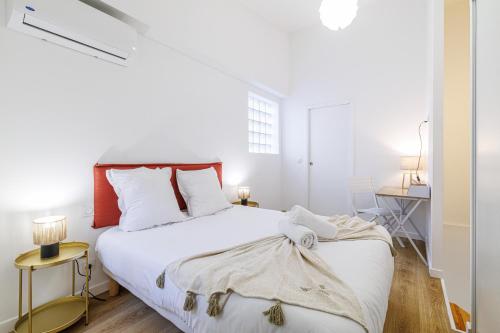 - une chambre avec un grand lit blanc et des oreillers blancs dans l'établissement 1 Bdr Duplex Downtown - AC, à Nice