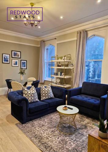 a living room with two blue couches and a table at Top Quality 2 Bed 1 Bath Apartments For Contractors By REDWOOD STAYS in Reading