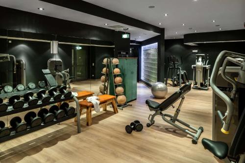 a gym with dumbbells and weights in a room at Pentahotel Rostock in Rostock
