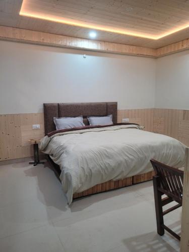 a bedroom with a large bed with a wooden headboard at Whoopers Hostel Kasol in Kasol