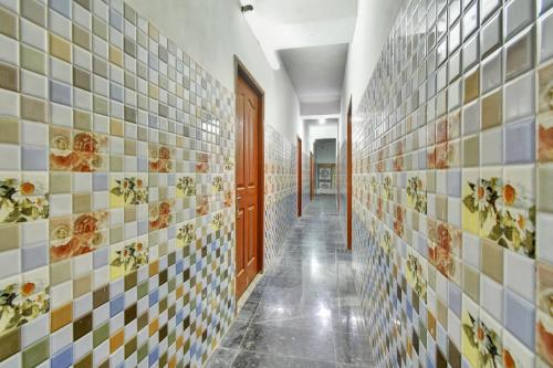 a hallway with tiles on the walls of a bathroom at Hotel O RKR Residency in Chennai