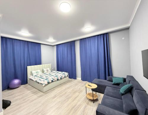 una sala de estar con una cama y un sofá en Тихий Замок, en Bishkek