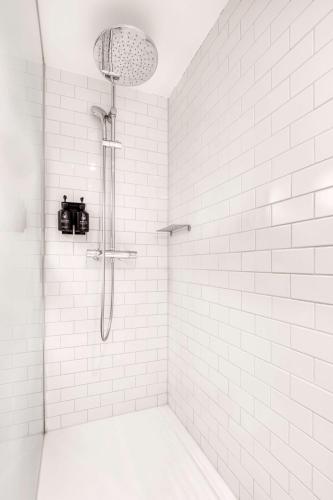 a bathroom with a shower with white tiles at pentahotel Brussels City Centre in Brussels