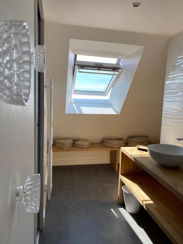 a bathroom with a sink and a window at La GRANGE BY CARO in Cantoin