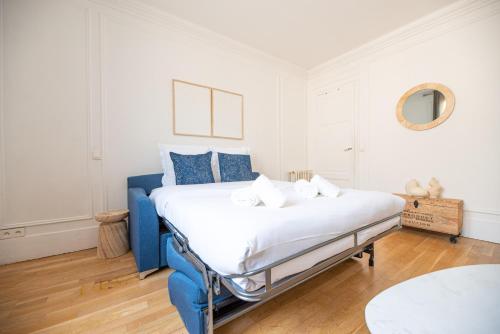 - une chambre blanche et bleue avec un grand lit dans l'établissement CIA - Studio by Arc de Triomphe, à Paris