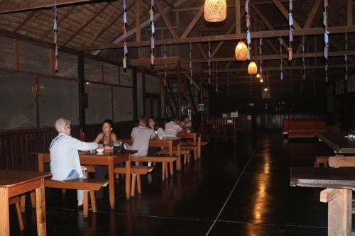 a group of people sitting at tables in a restaurant at Tambopata Haven lodge in Puerto Maldonado