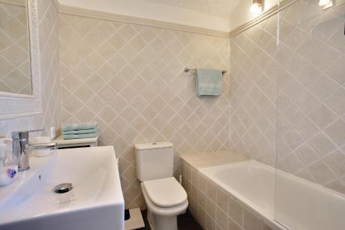 a bathroom with a white toilet and a sink at Beachfront townhouse with spectacular seaview in Estepona